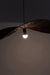 Dual colour Raffia Pendant Lamp illuminated, showing the curved shade in silhouette around a glowing bulb.