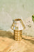 Brass-Aged Table Lamp on a wooden surface beside a textured wall