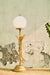 Sheaf Table Lamp wide view beside a plant