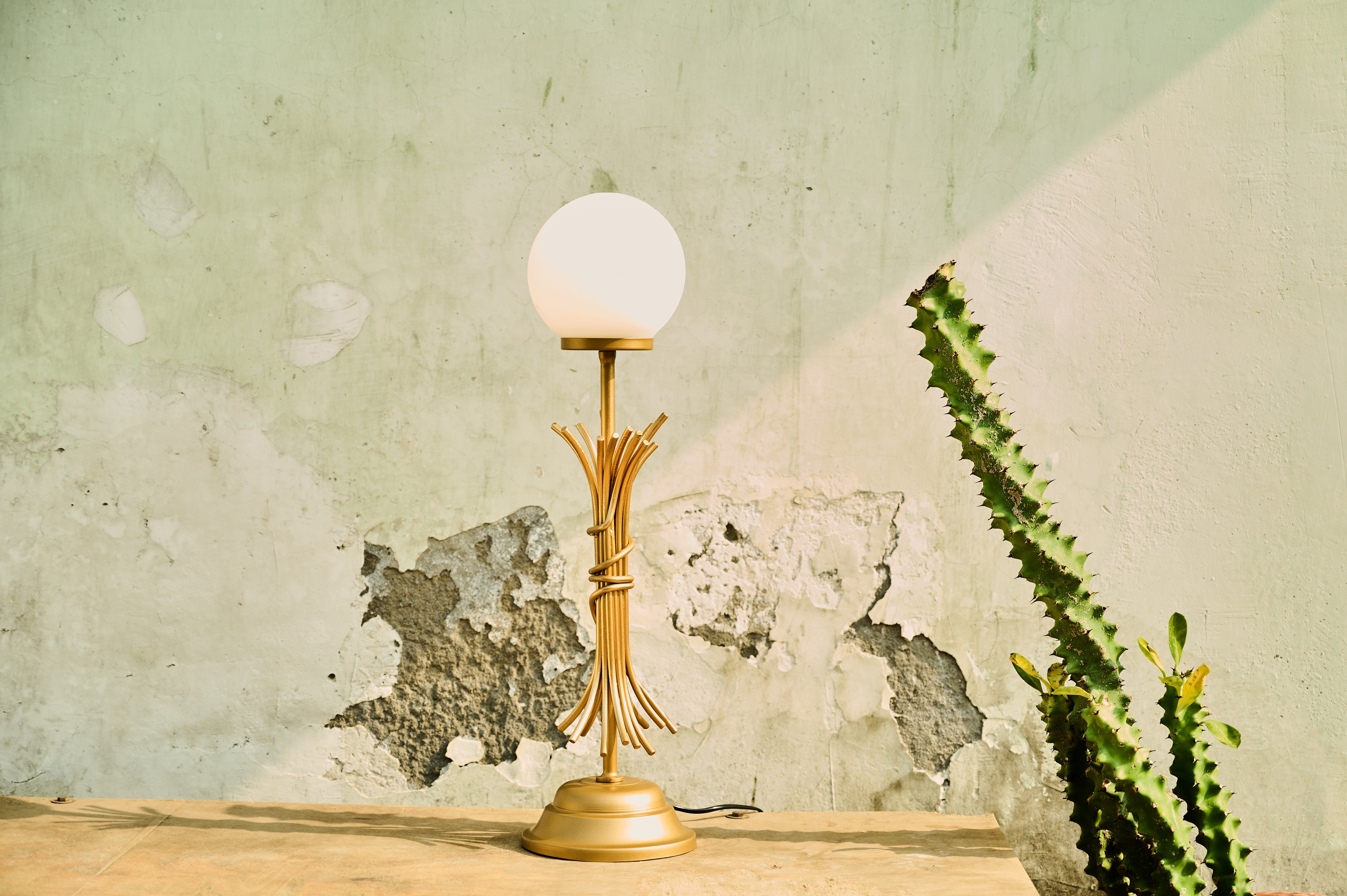 Sheaf Table Lamp wide view beside a plant
