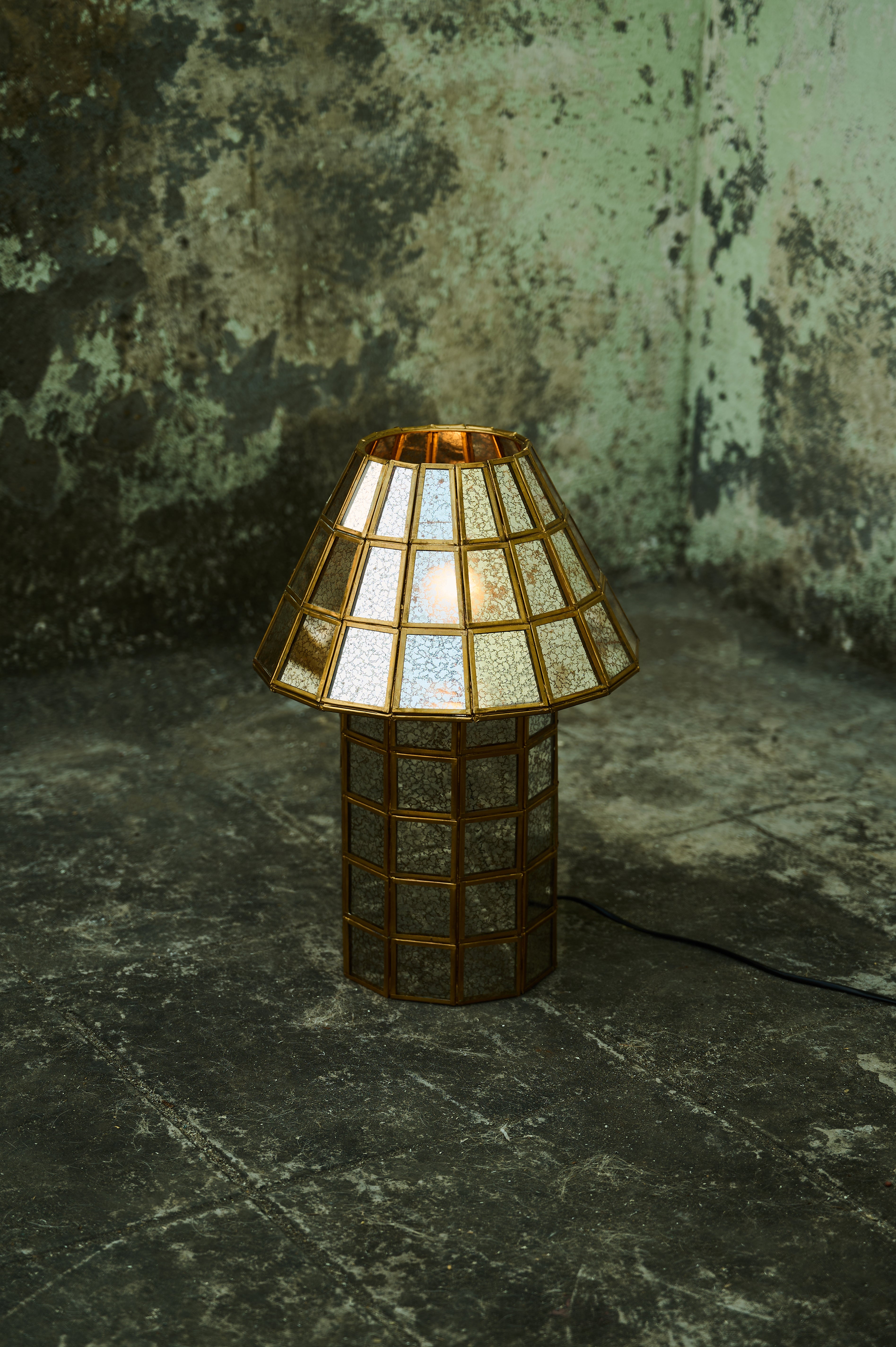 Brass-Aged Table Lamp illuminated against a dark wall