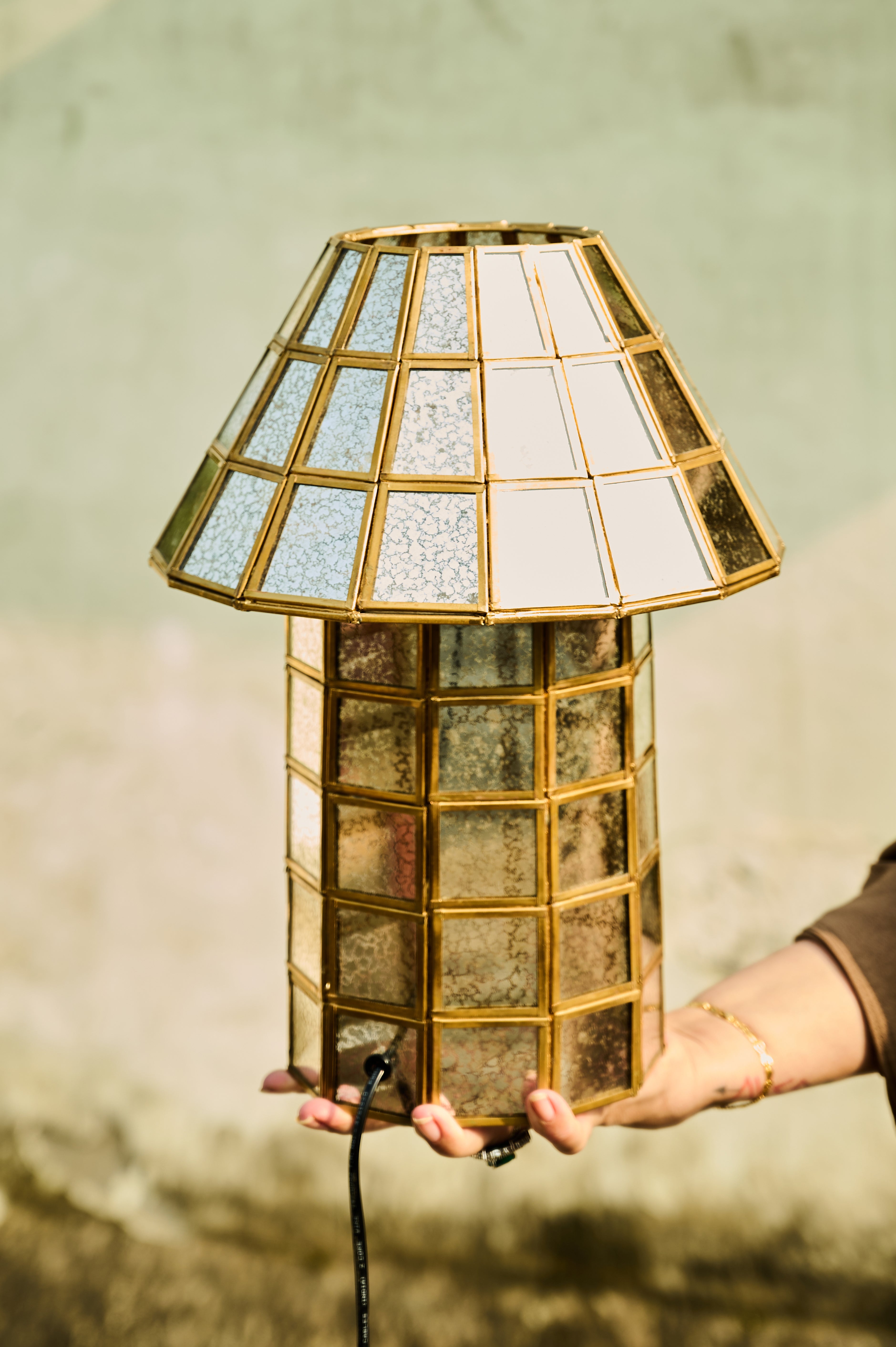 Brass-Aged Table Lamp held in a hand