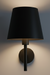 Black wall lamp with a shade on a neutral background
