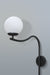 Contemporary arched wall lamp with a sleek black design and a soft-diffused white lampshade, mounted in a living room