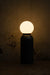 Moon Table Lamp illuminated against a dark wall
