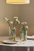 Table setting with fluted vases set with pink and white flowers.