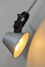 Industrial-style movable wall lamp with metal arm and clean geometry, mounted on a neutral wall.