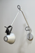 Minimal wall-mounted lamp with a movable arm, allowing precise control of light direction.
