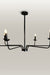 Minimalist chandelier featuring six black metal arms and candle flame light bulbs, illuminating a contemporary dining area.