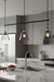 Modern kitchen with pendant lights, marble island, and stainless steel appliances.