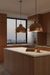 Modern kitchen with wooden cabinets, a island, and pendant lights.