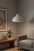 Modern living room with a textured pendant light, gray sofa, and wooden coffee table.