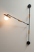 Modern wall-mounted light fixture with adjustable arm on a white wall