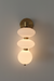 Modern wall light fixture with three glass shades on a gray background