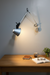 Movable wall lamp with adjustable arm and focused light, designed for flexible wall mounting.
