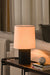 Modern table lamp on a side table with a cozy living room background