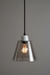 Pendant light with smoked glass shade and visible bulb on a gray background