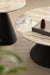 Close up of coffee and side tables with polished marble tops and bold black pedestal bases.