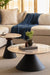 Round marble coffee table and accent table nested with matte black bases styled with books and plants.