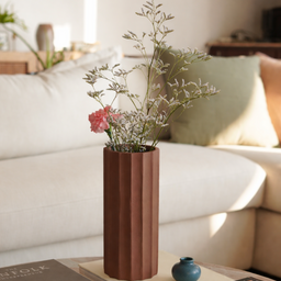 Brown vase with flowers on a coffee table in a living room setting