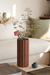Brown vase with flowers on a coffee table in a living room setting