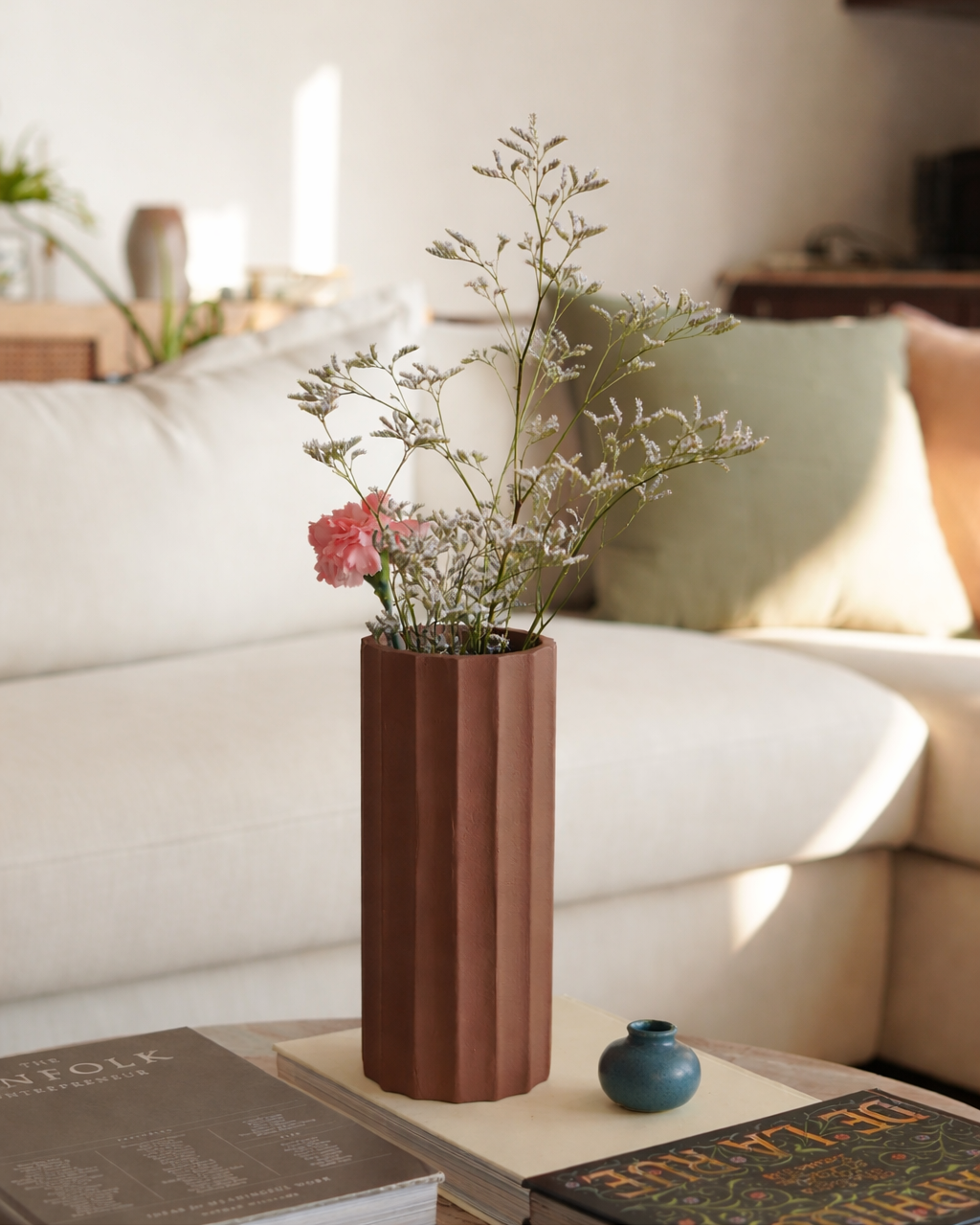 Brown vase with flowers on a coffee table in a living room setting