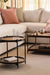 Wood and metal side and coffee tables in cozy modern living room setup.