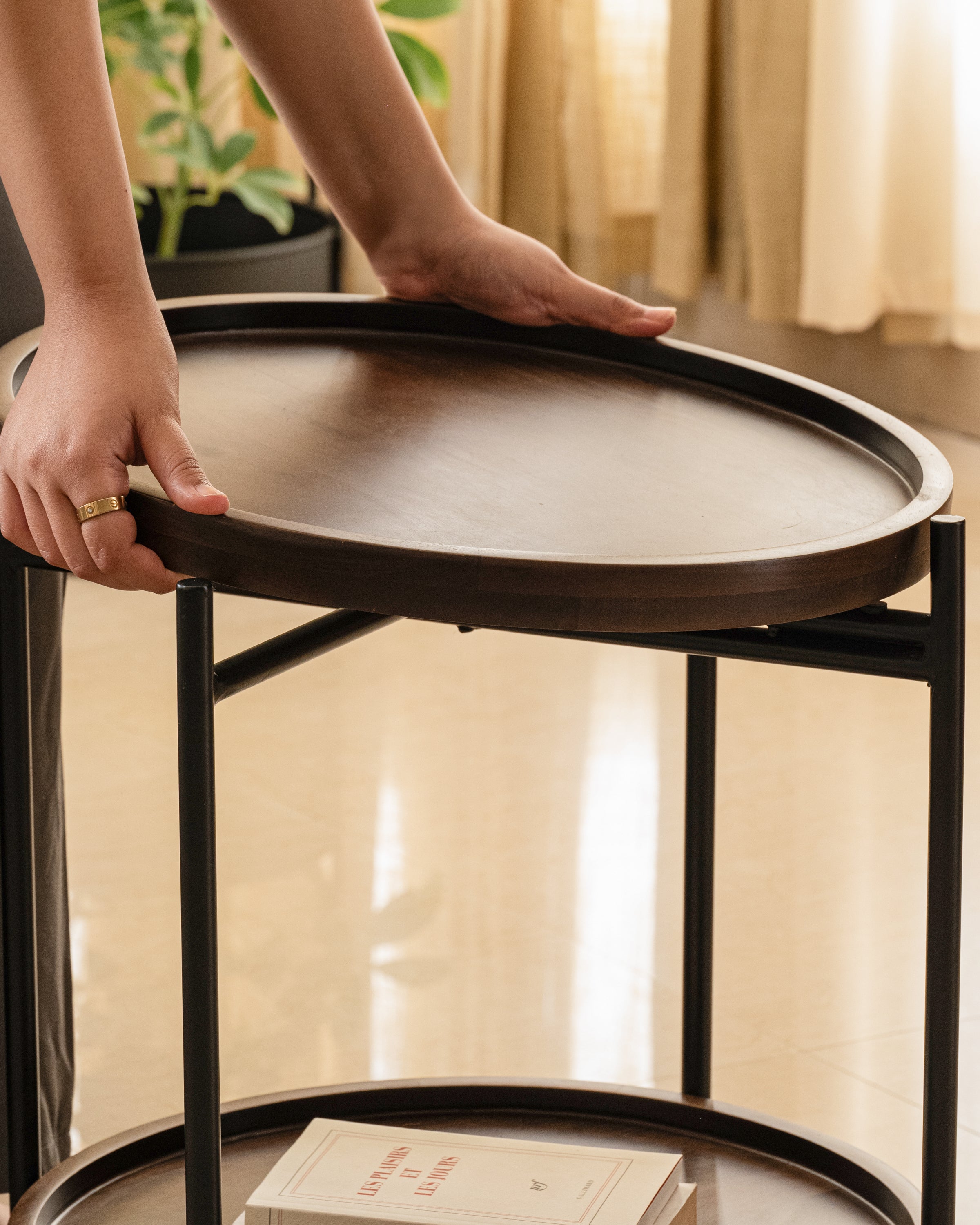 Modern round side table with lift-off wood tray and storage shelf.