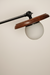 Wall-mounted lamp with wooden shade and white bulb on a beige background