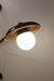 Wall-mounted light fixture with a round bulb on a neutral background