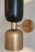 Wall-mounted light fixture with black and gold design on a neutral background