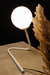 White lamp on a beige surface with a dark background