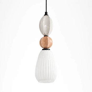 A modern pendant light featuring three stacked glass orbs , a glossy white oval, a matte copper sphere, and a ribbed frosted white teardrop , suspended by a black cord.