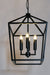 The Farmhouse Opulence Candelabra Barn Pendant suspended gracefully above a rustic farmhouse dining table, emitting a warm and inviting glow.