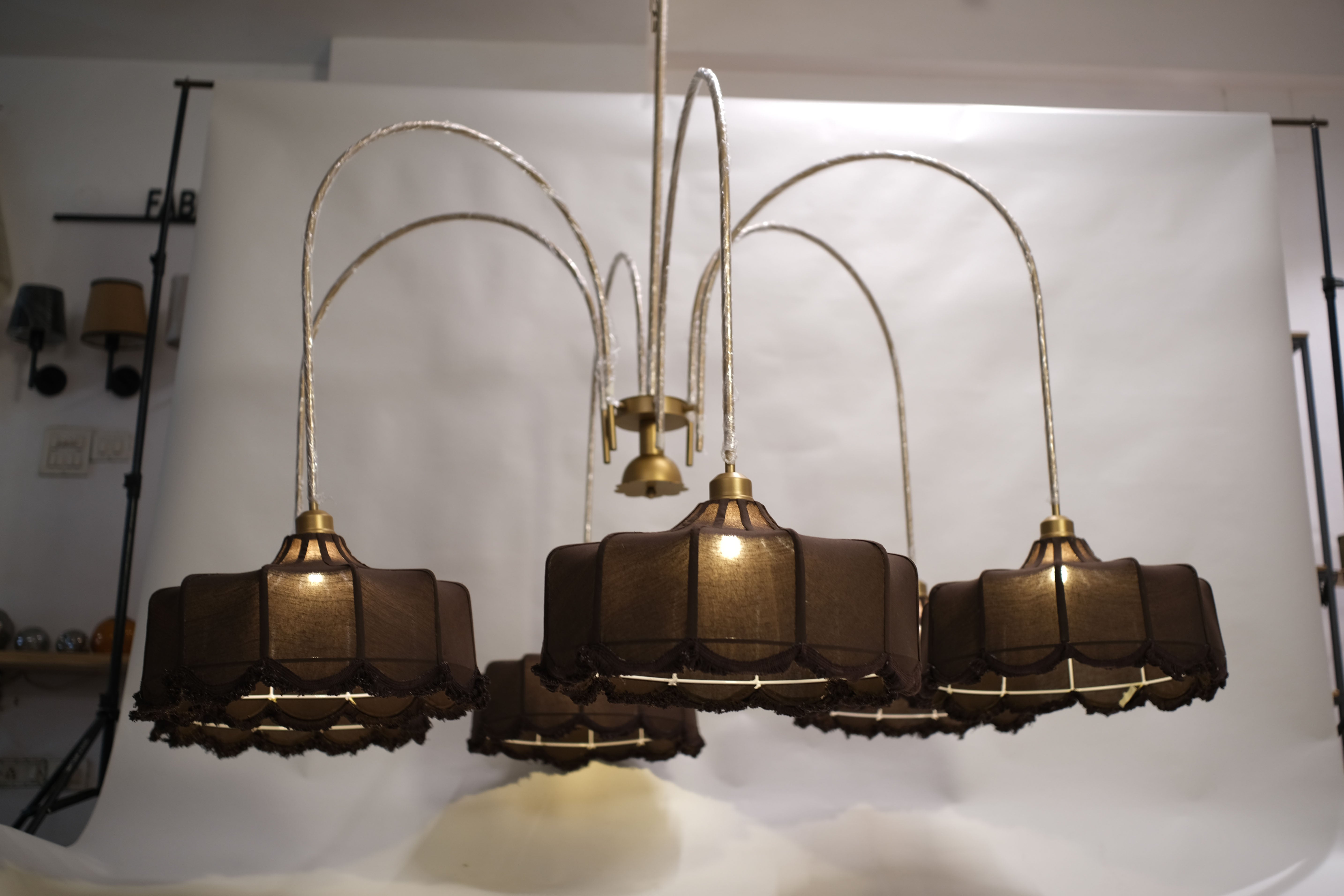 Luxurious modern chandelier featuring multiple tiers of warm glowing lights, suspended in a grand entryway.
