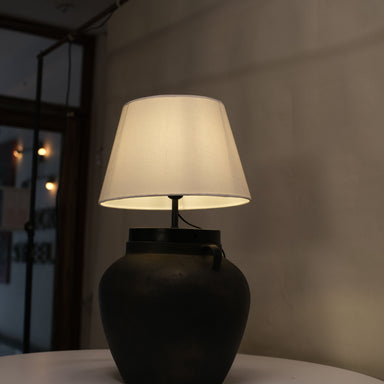 Chic table lamp with a sleek sand-textured base and a classic white shade, ideal for accenting any decor