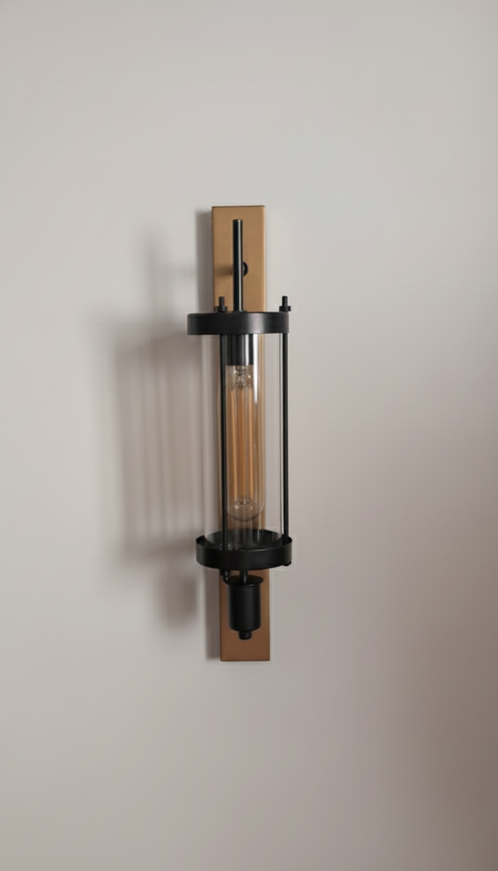 Modern wall-mounted light fixture with a metallic finish on a neutral background