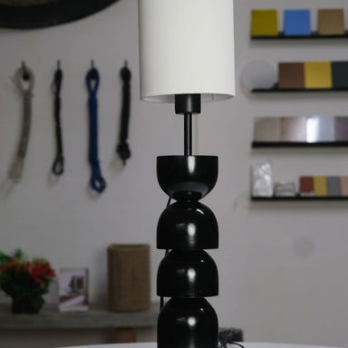 Sleek black and white table lamp with rounded segments and a modern minimalist design.
