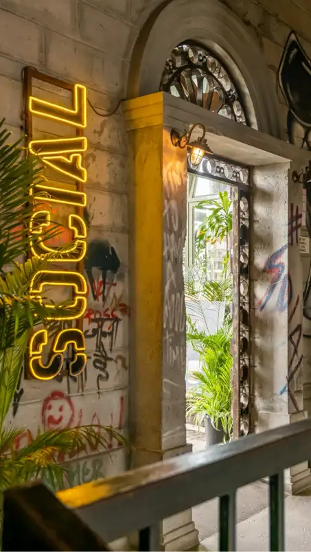 A glowing yellow neon sign that spells ’social’ in bold, uppercase letters.
