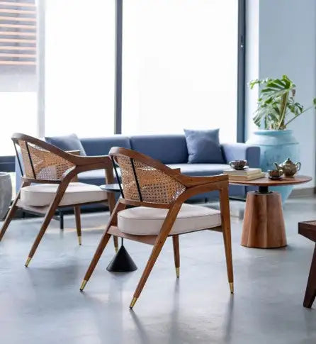 Modern wooden chairs with woven cane backs and cream-colored cushions.