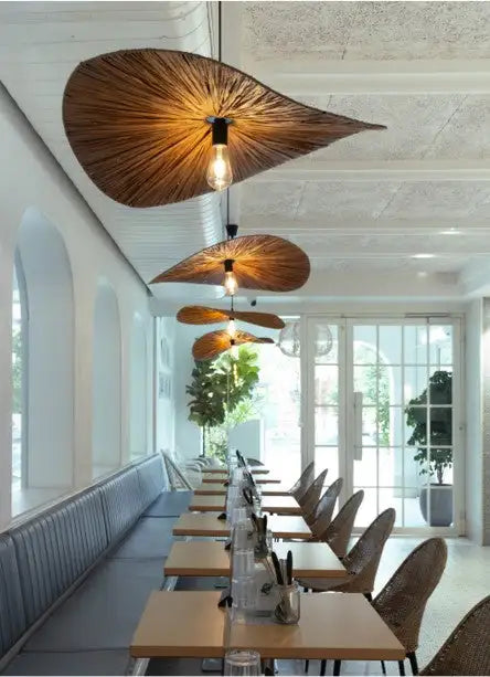 Warm-toned, leaf-shaped pendant lights with a woven wooden texture hang from the ceiling.