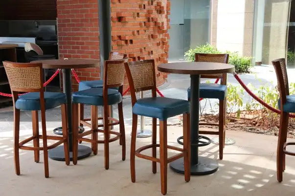 Wooden bar stools with woven backrests and teal upholstered seats.
