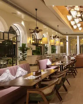 The image shows a cozy, well-lit restaurant interior with wooden tables and chairs.