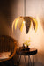 Woven pendant light hanging above a wooden table with a chair in a softly lit room.