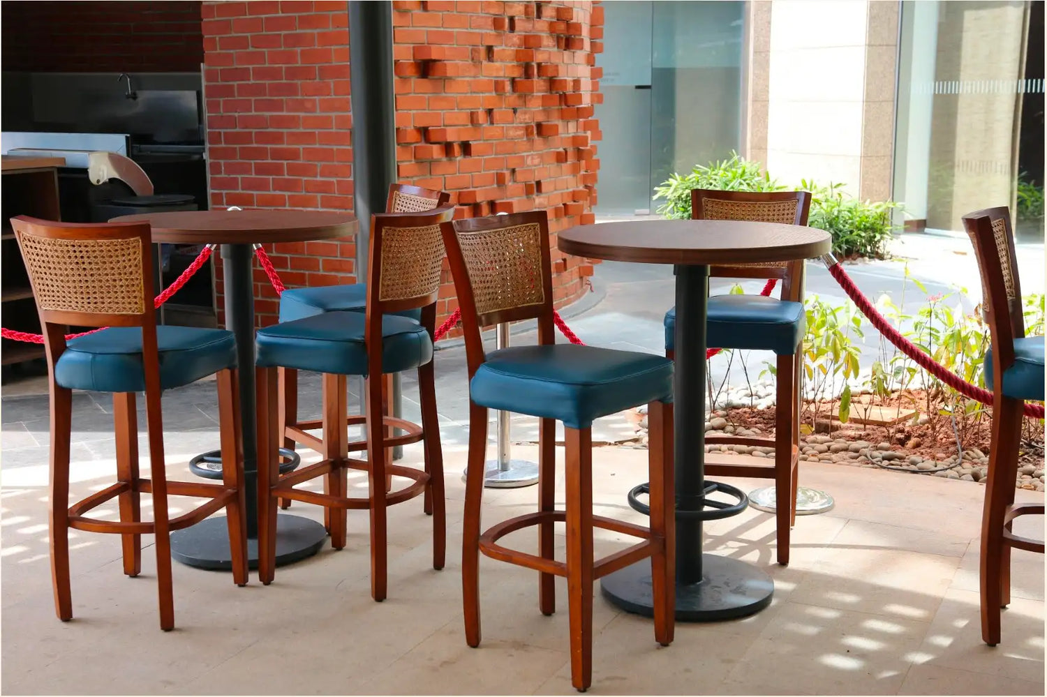 Wooden bar stools with woven backrests and teal upholstered seats.