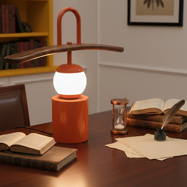 Desk lamp on a wooden desk with books and stationery items.