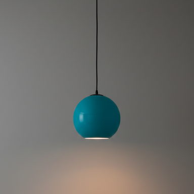 Turquoise pendant light hanging against a gray wall