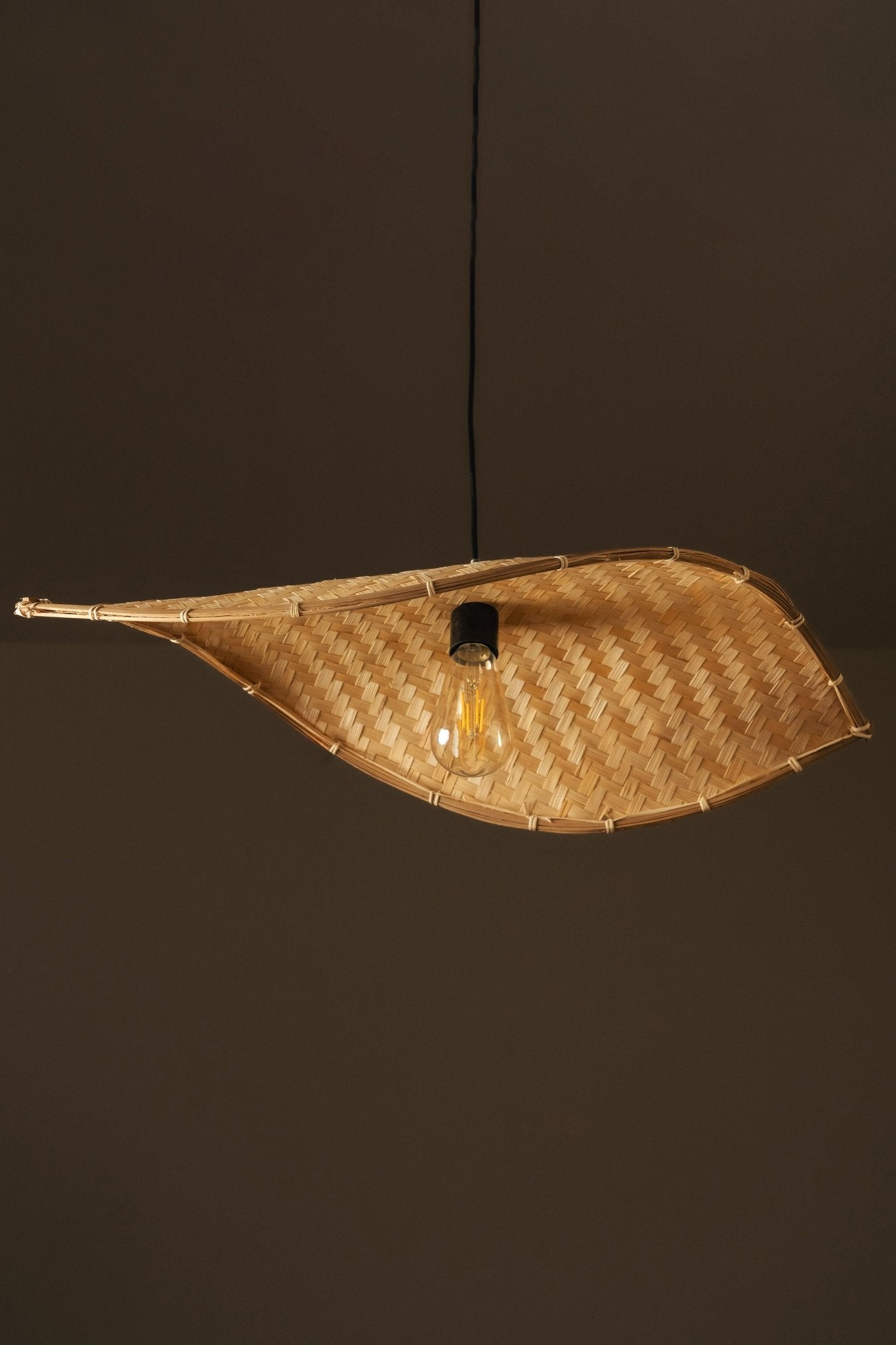 Thin wavy bamboo hanging lampshade handcrafted with elegant curved weaving, offering a warm ambient glow and a modern eco-friendly décor aesthetic.