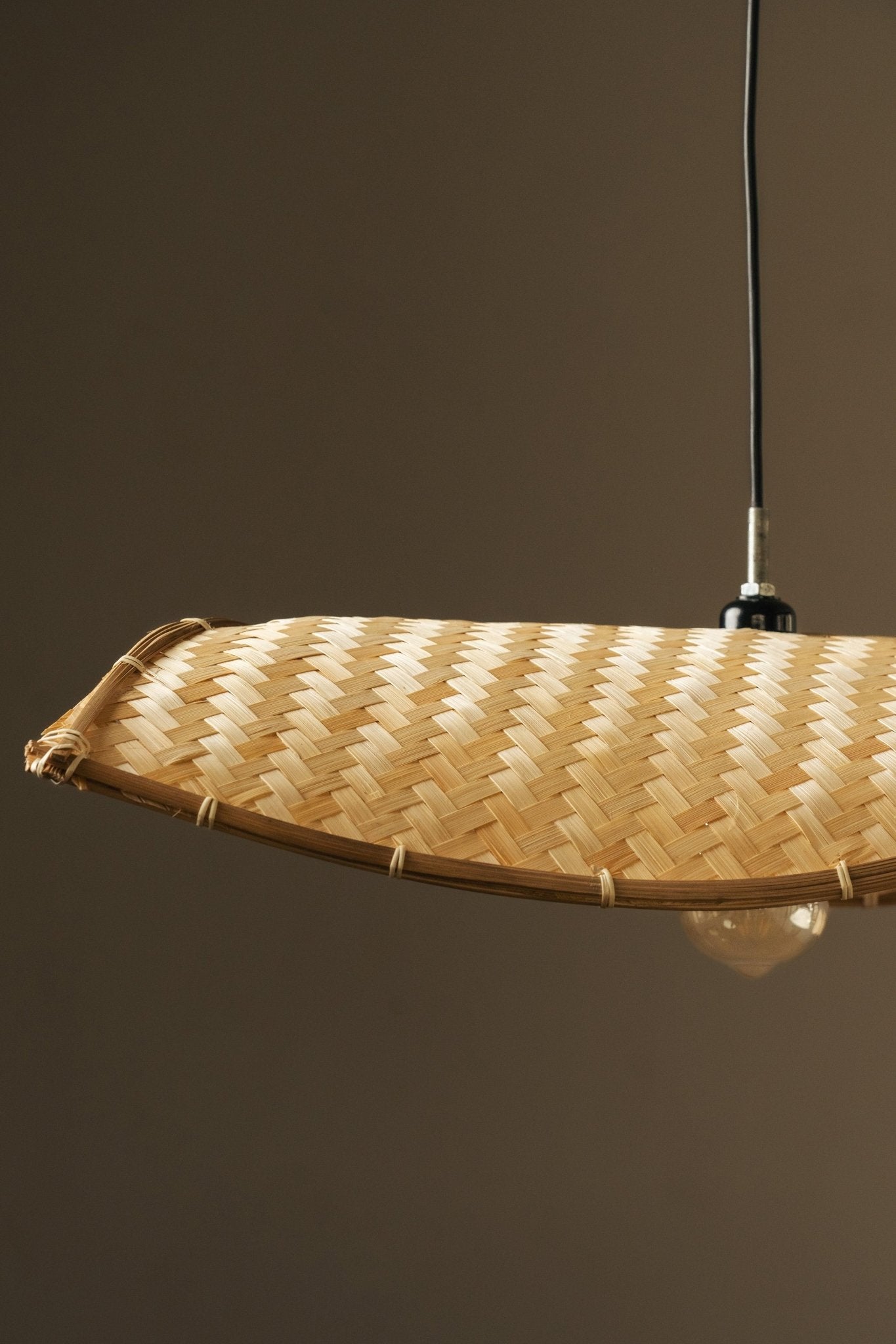 Thin wavy bamboo hanging lampshade handcrafted with elegant curved weaving, offering a warm ambient glow and a modern eco-friendly décor aesthetic.