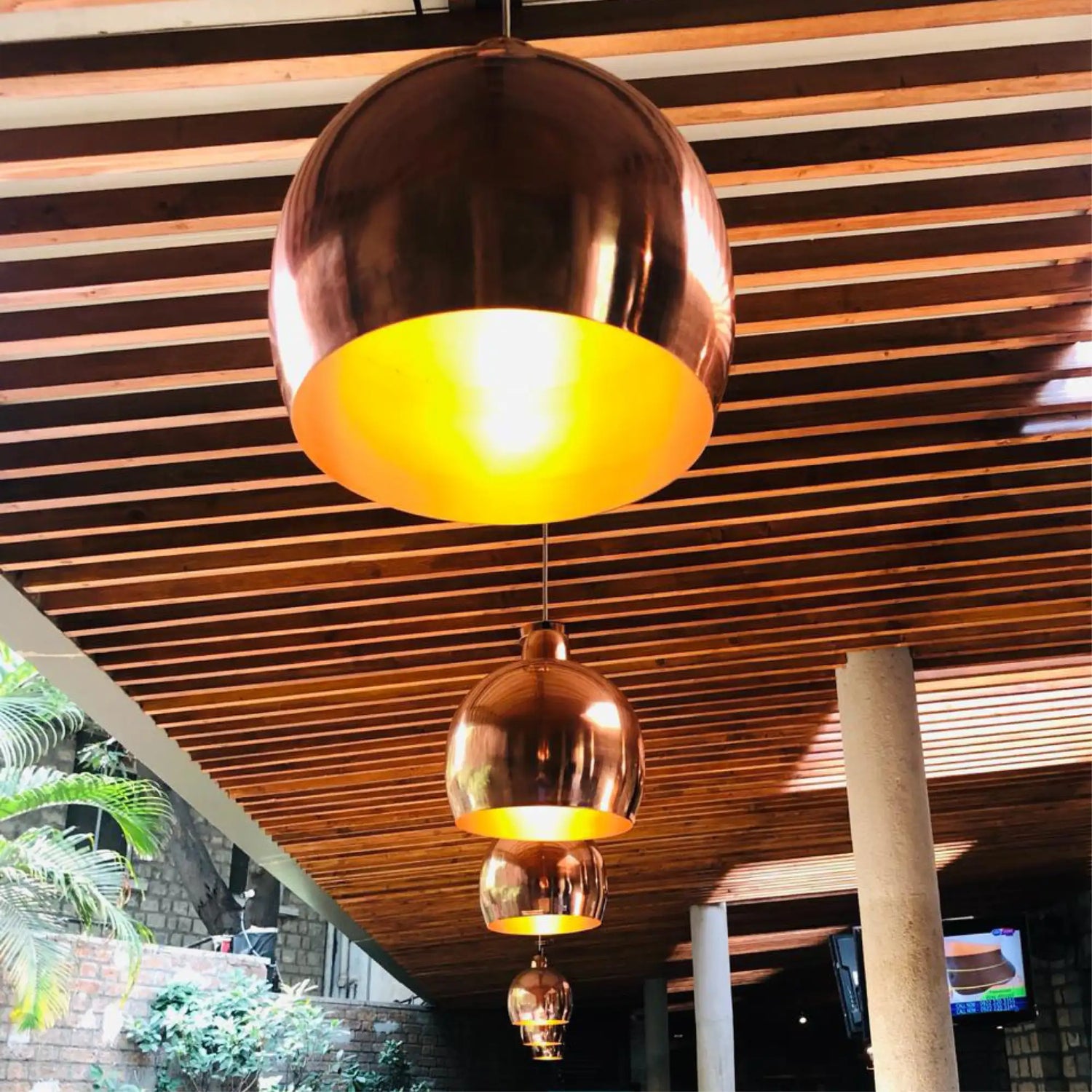 Copper dome pendant light with a warm yellow interior glow.